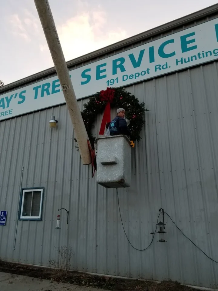 Man hanging Holiday Wreath at Lamay Tree Service